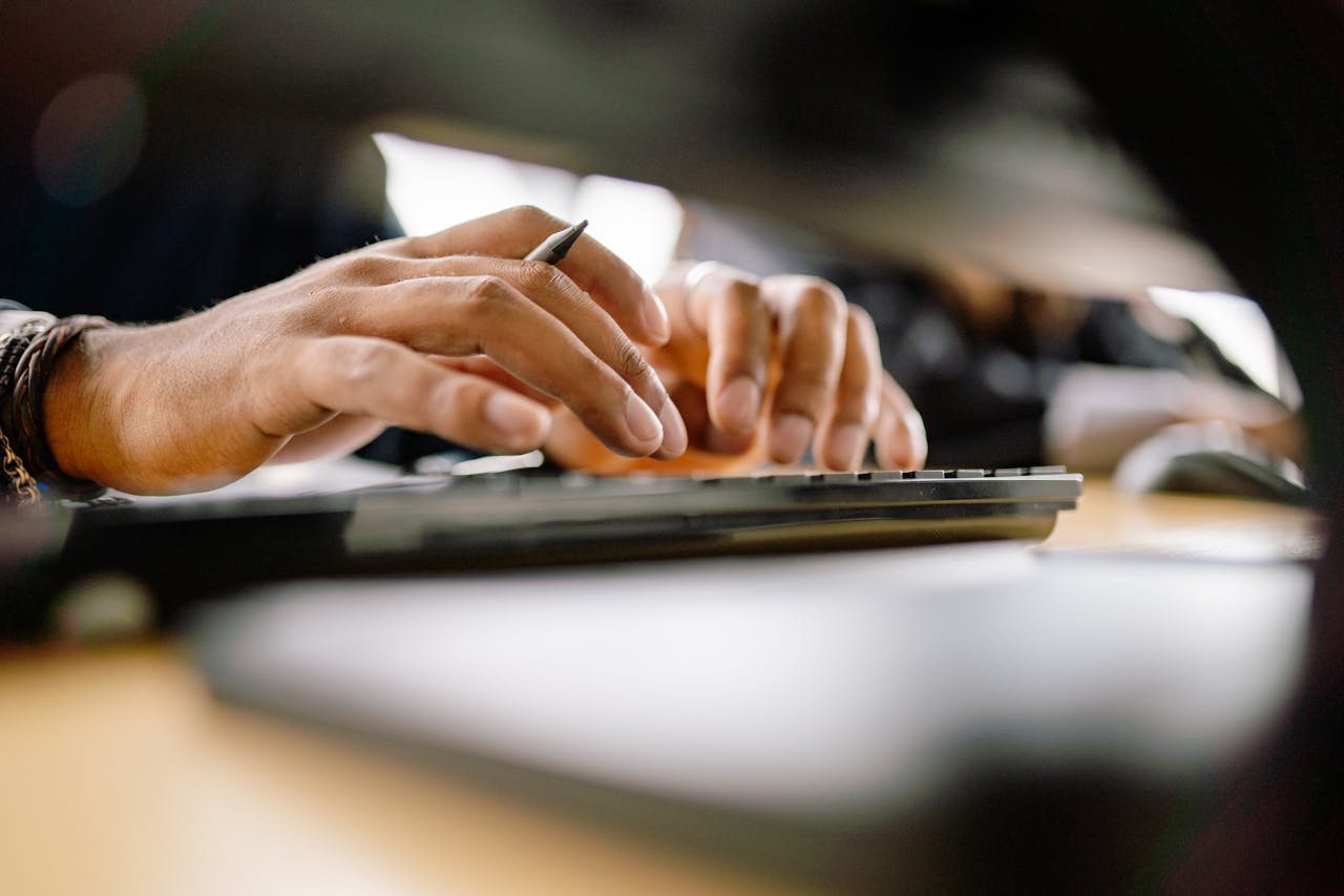 hands typing on a computer keyboard