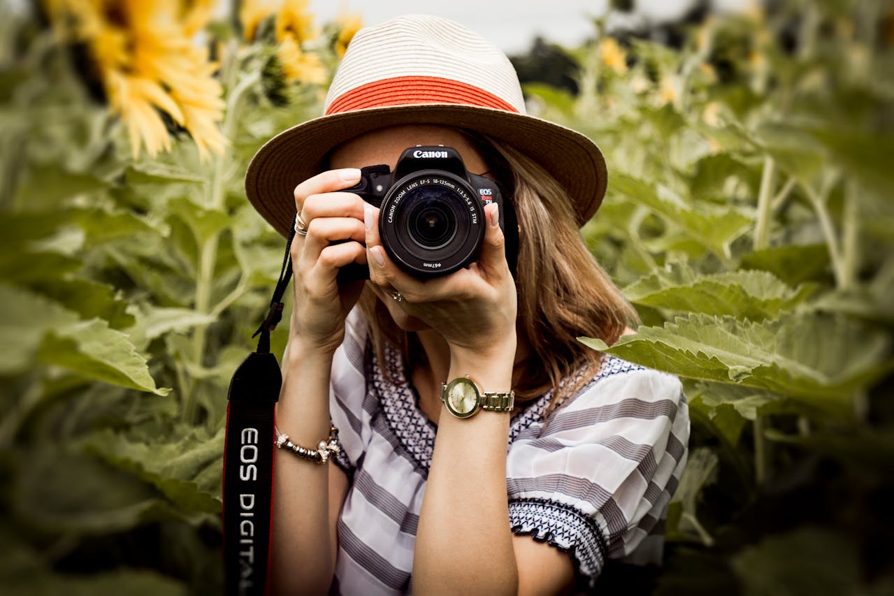 Woman in hat pointing camera at the camera