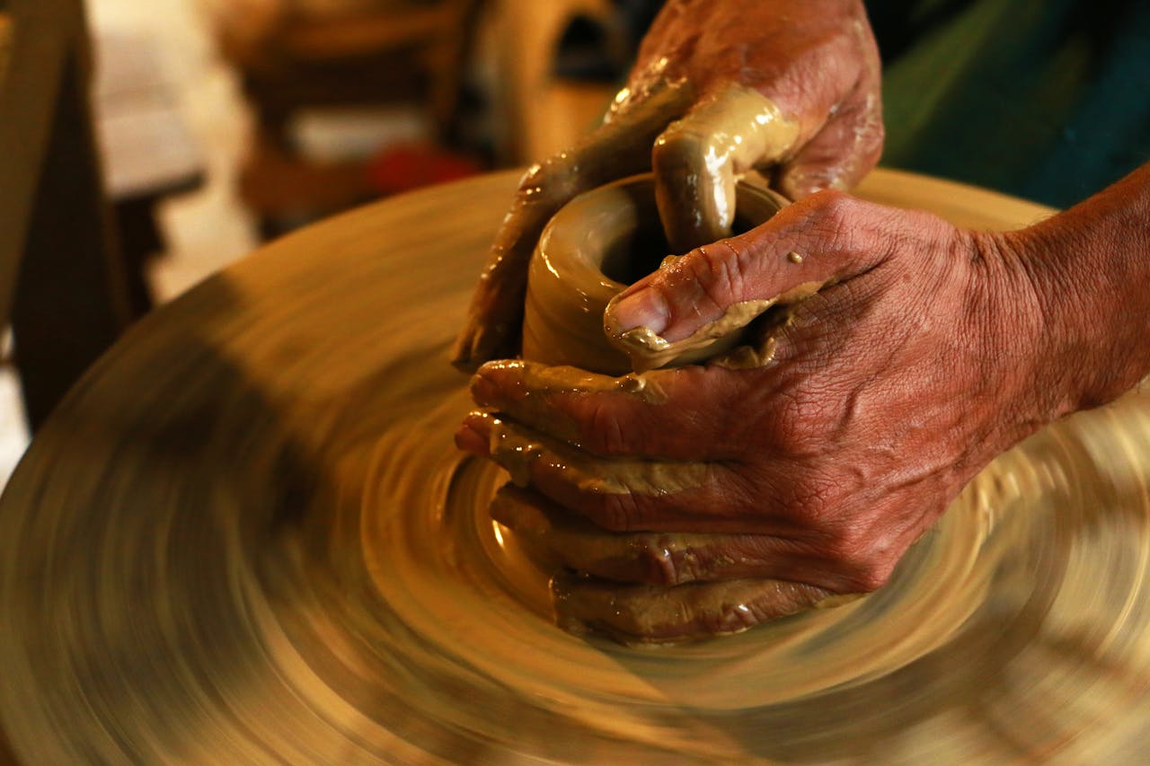 Hands forming something in pottery